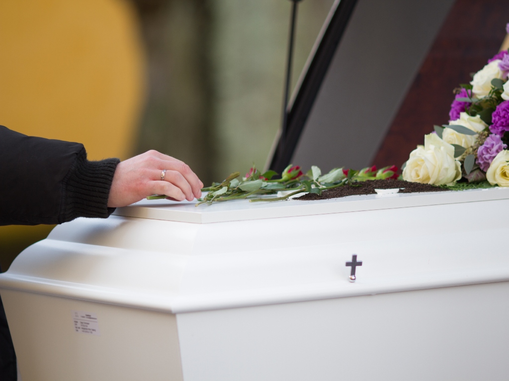 musica funerale chieri chiesa Parente di un defunto accarezza la bara
