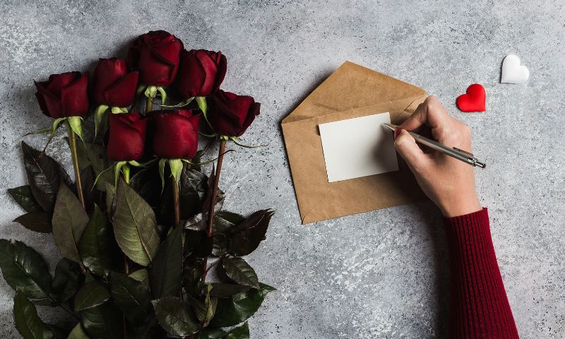 Mano di donna scrive su una lettera le frasi per i 25 anni di matrimonio
