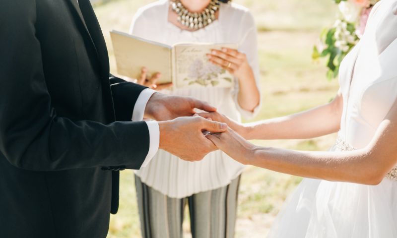 Marito e moglie si tengono per mano durante le letture del matrimonio civile